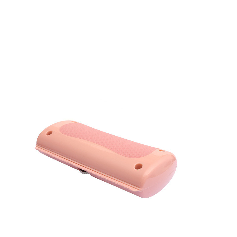 Pink pet grooming comb with textured grip pad and oval holes on the handle