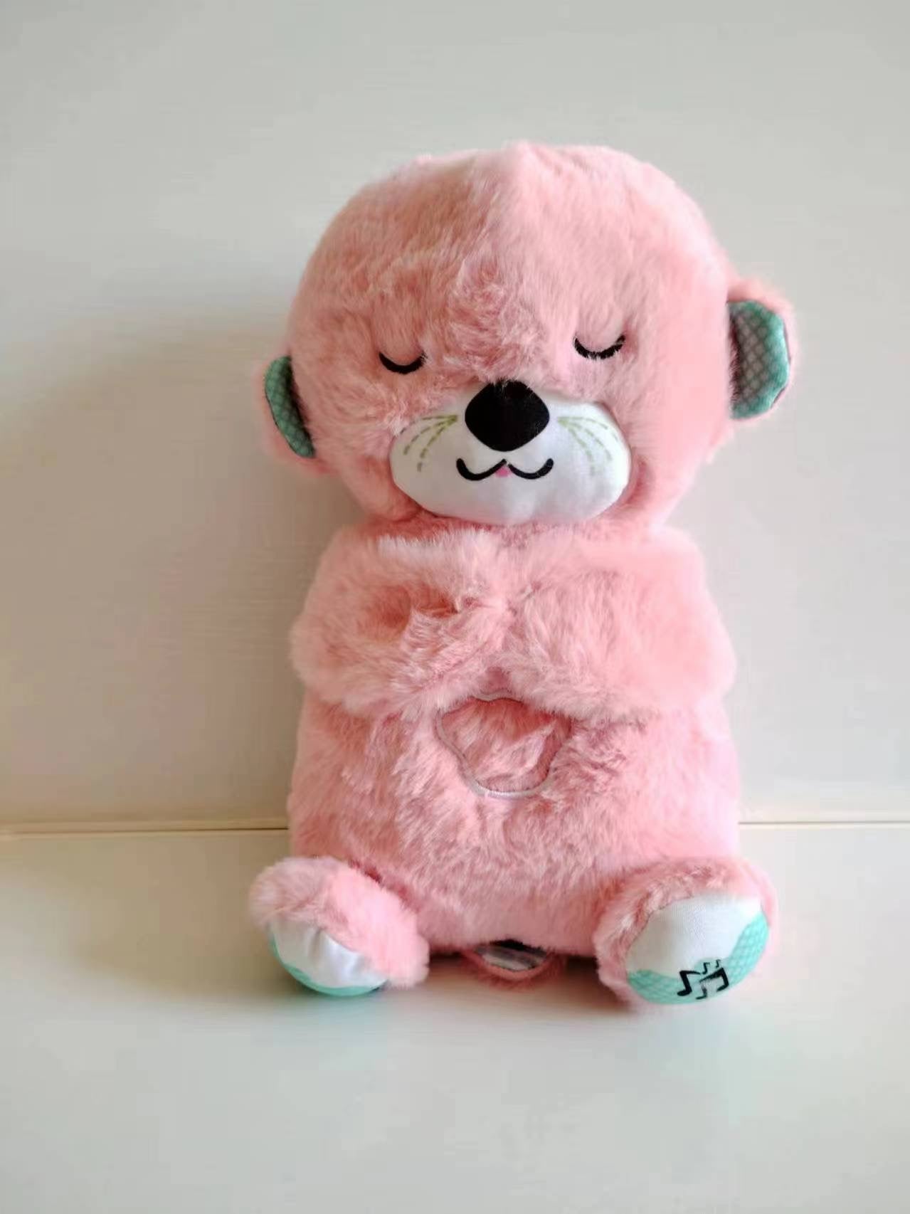 Plush baby sound machine, pink koala with black nose, closed eyes, teal accents
