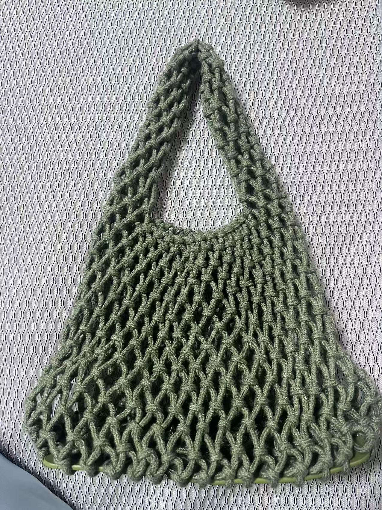 Olive green rope bucket bag with hollow net weave and short loop carry handle