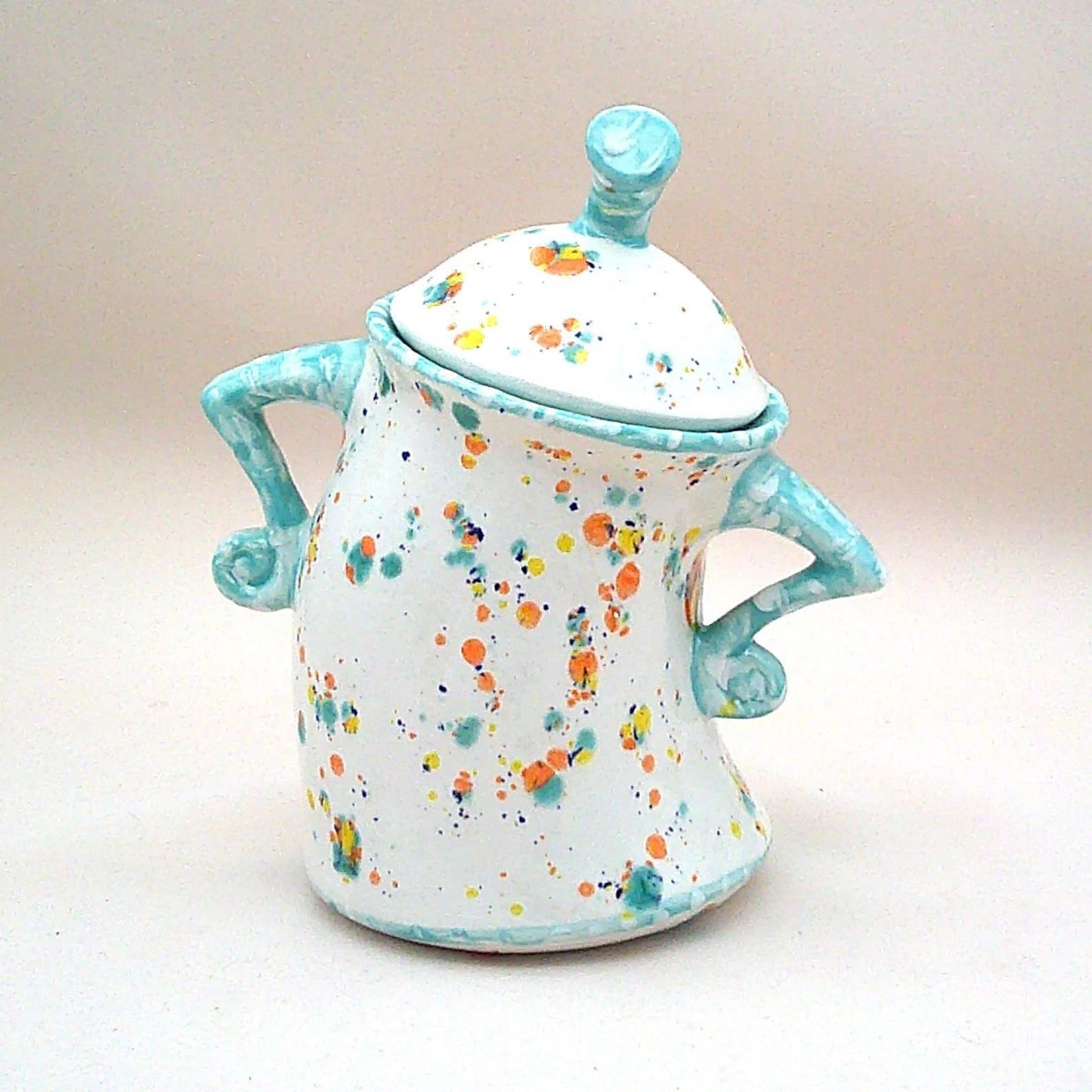 Decorative resin lidded jar, white with colorful dots, turquoise side handles and round lid knob