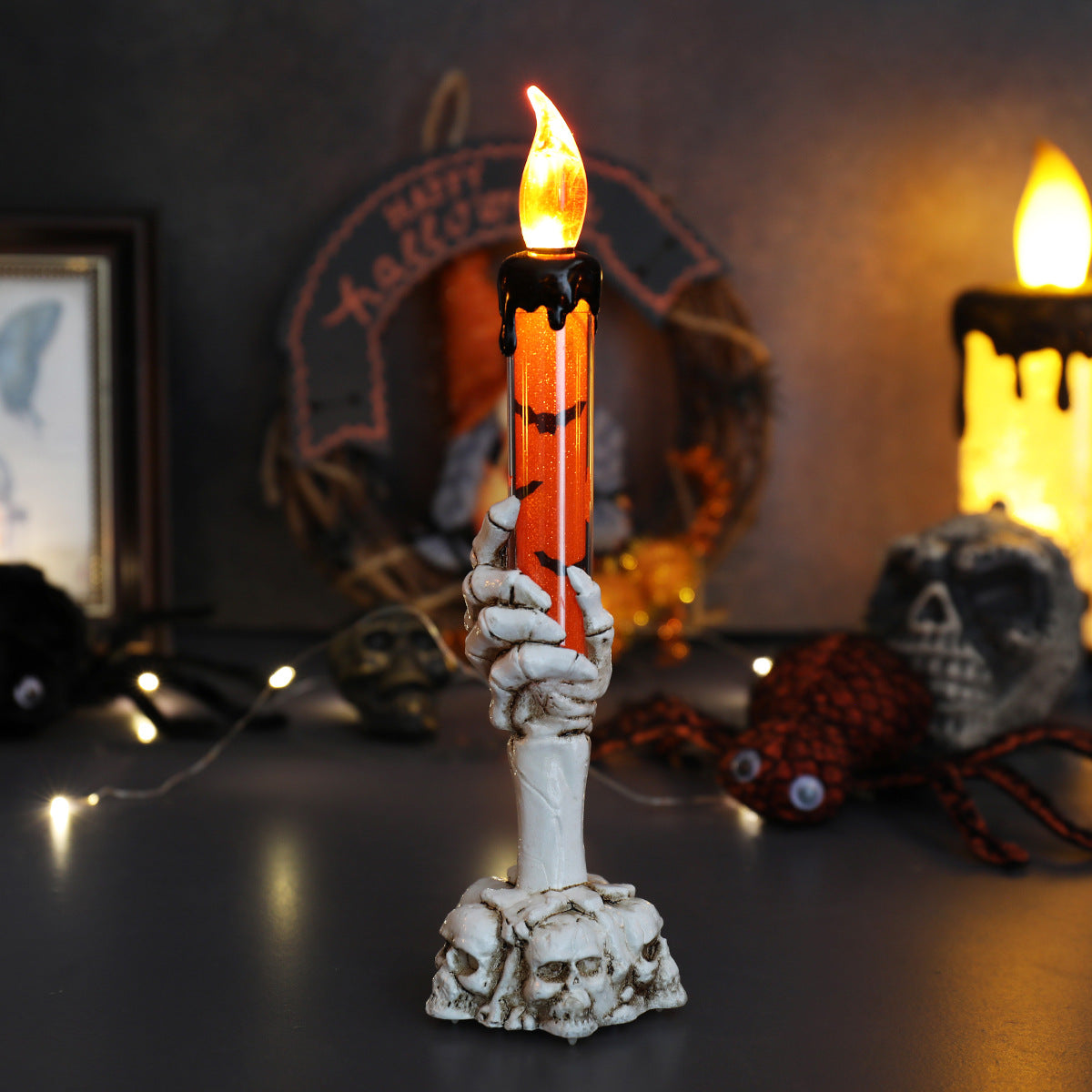 LED ghost hand candle with skull base, orange glow flame and white ghost hand