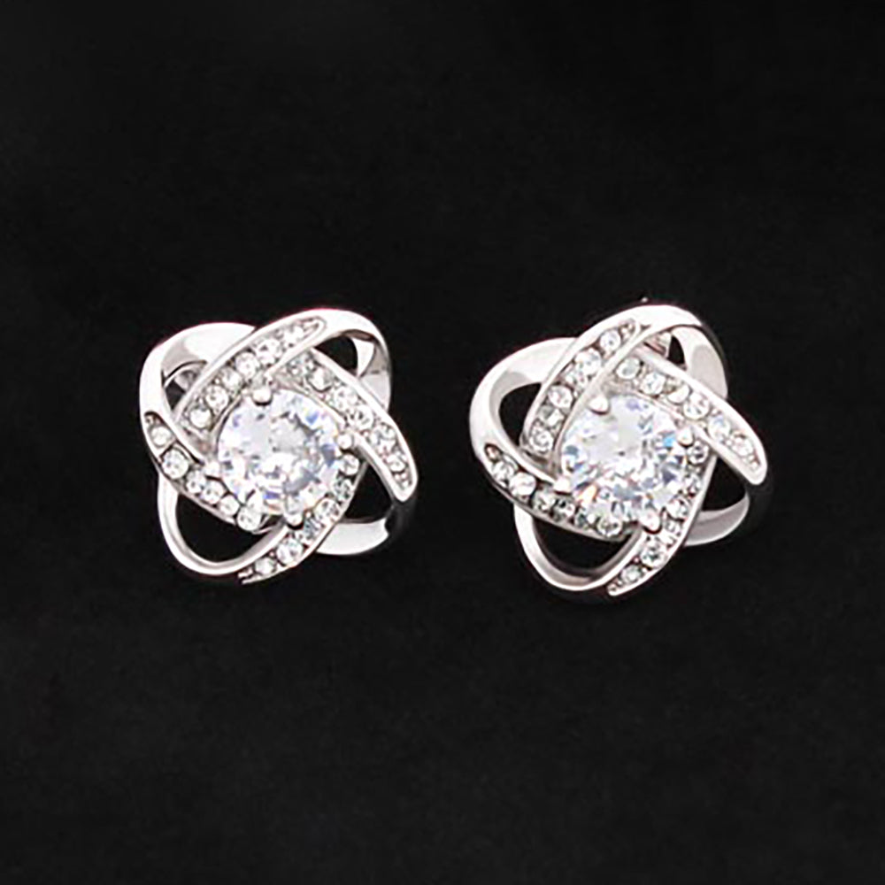 Love knot stud earrings in white gold tone with oval CZ center and sparkling crystal ring.