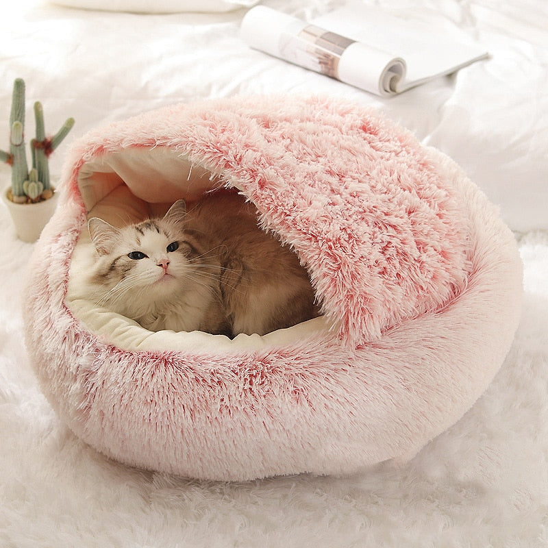 Soft pink plush pet bed with raised rim and tunnel entrance, cat sleeping inside