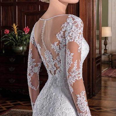 White mermaid wedding dress back view with sheer lace sleeves and corset detailing