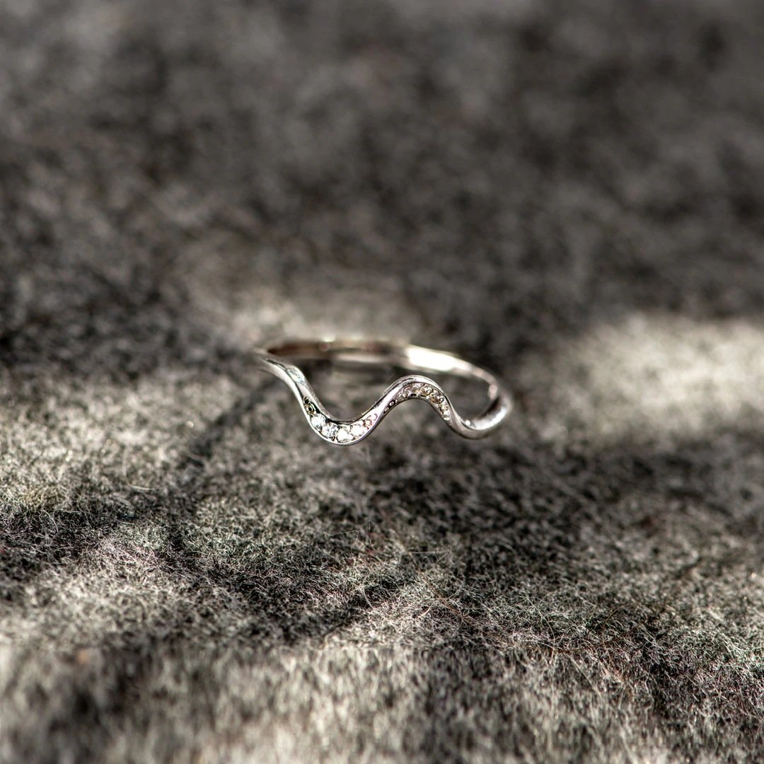 Silver open adjustable ring with wavy geometric top and small clear stone accents