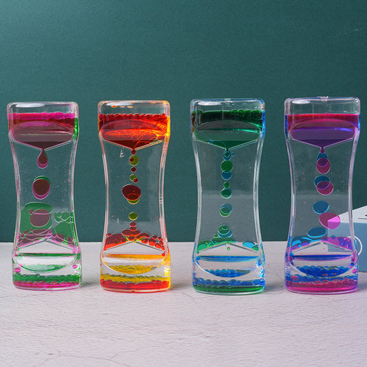 Two-color liquid hourglass timer with pink top and green bottom, floating colored beads