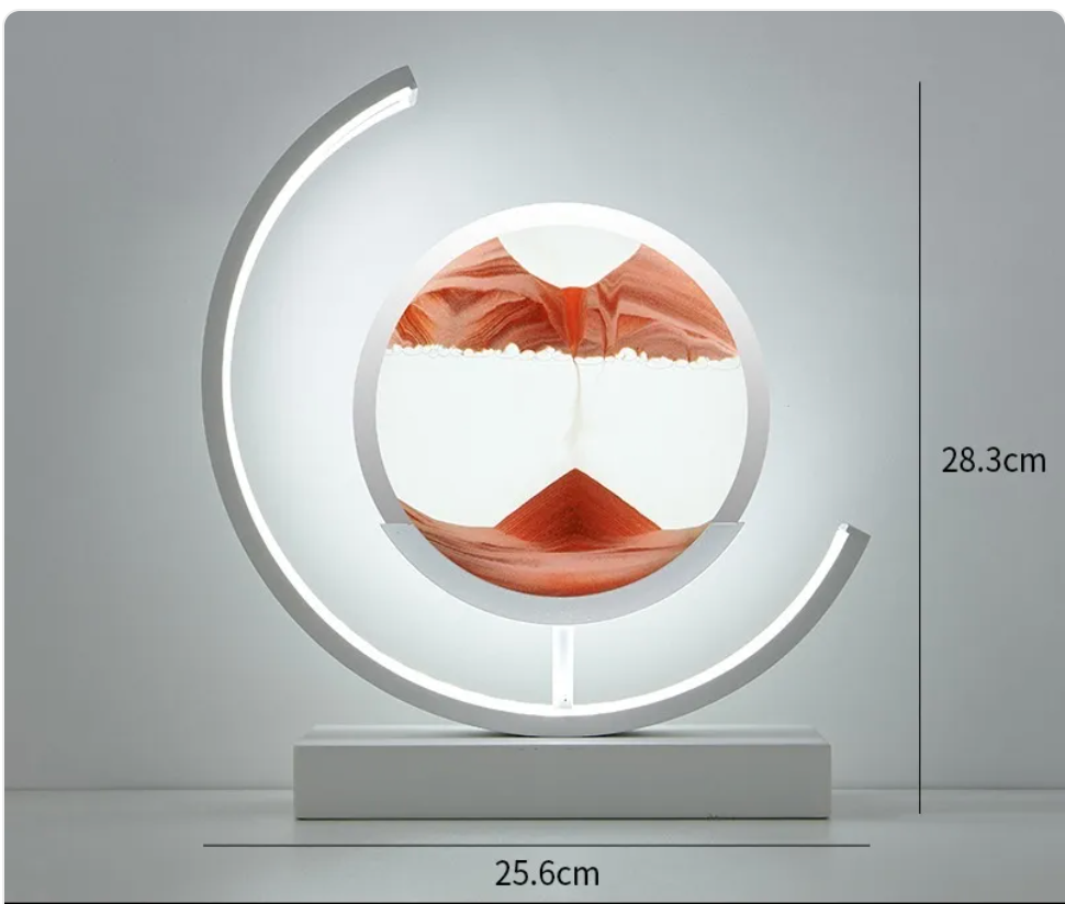 Hourglass table lamp with white crescent LED ring, round glass insert, red wave art, white base.