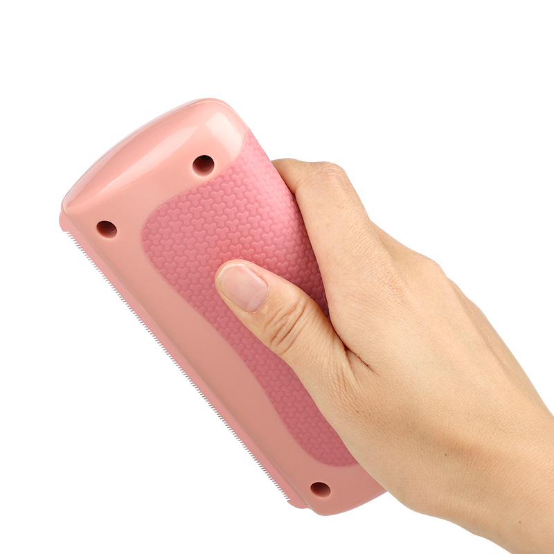 Pink pet grooming comb with dual-sided teeth and finger-grip handle holes