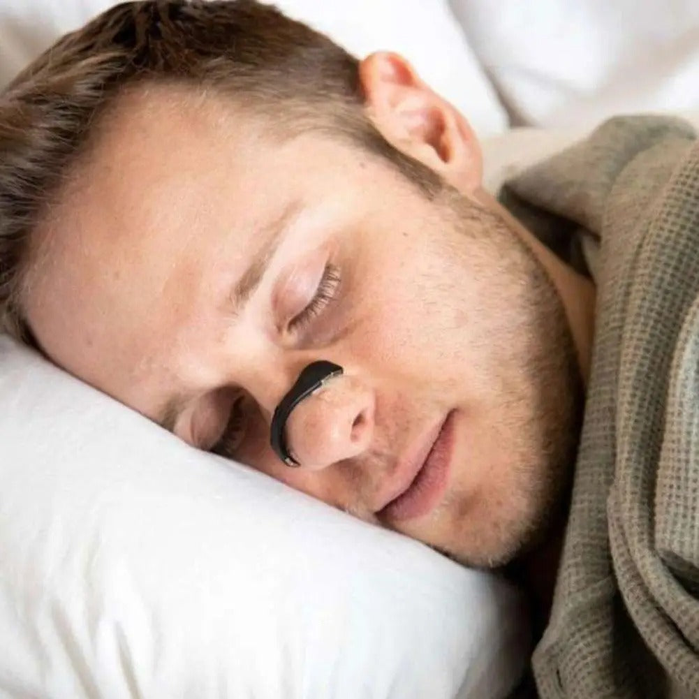 Man sleeping with black nasal dilator strip across the nose