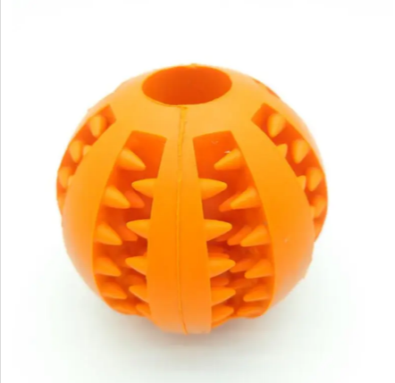 Dog treat dispensing rubber ball in orange with raised spike pattern and center seam