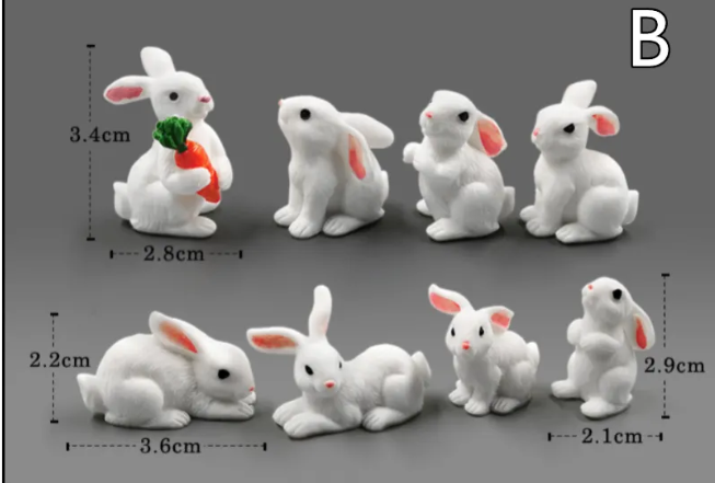 Assorted mini white rabbit resin figurines with red ears and orange accessory details.