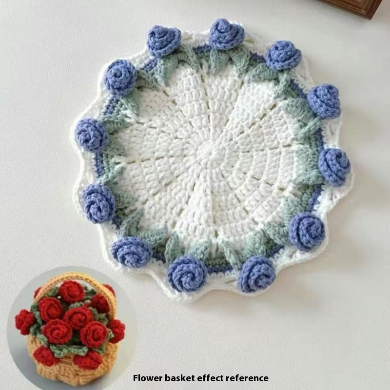 Round crocheted coaster with cream center and blue rose border with green edging