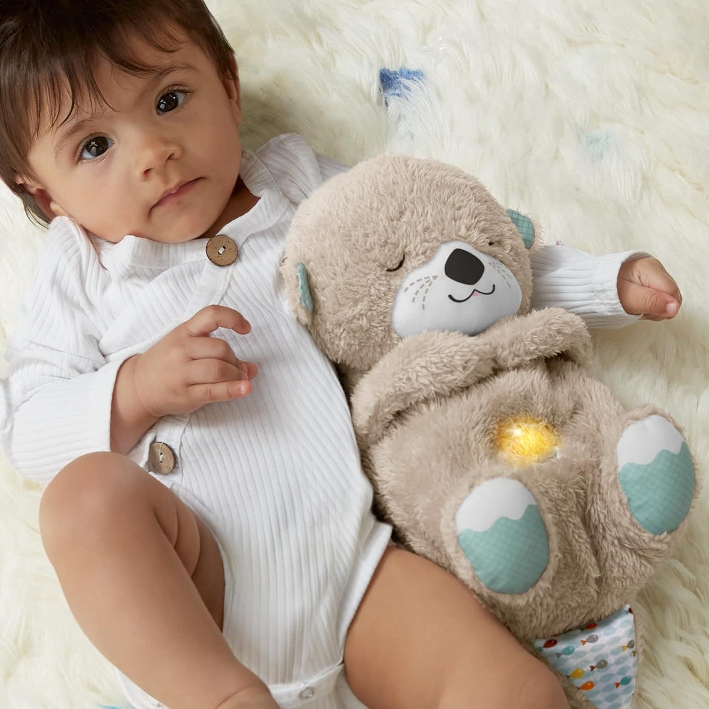 Gray plush bear sleep aid held by a baby, orange glowing belly heart patch