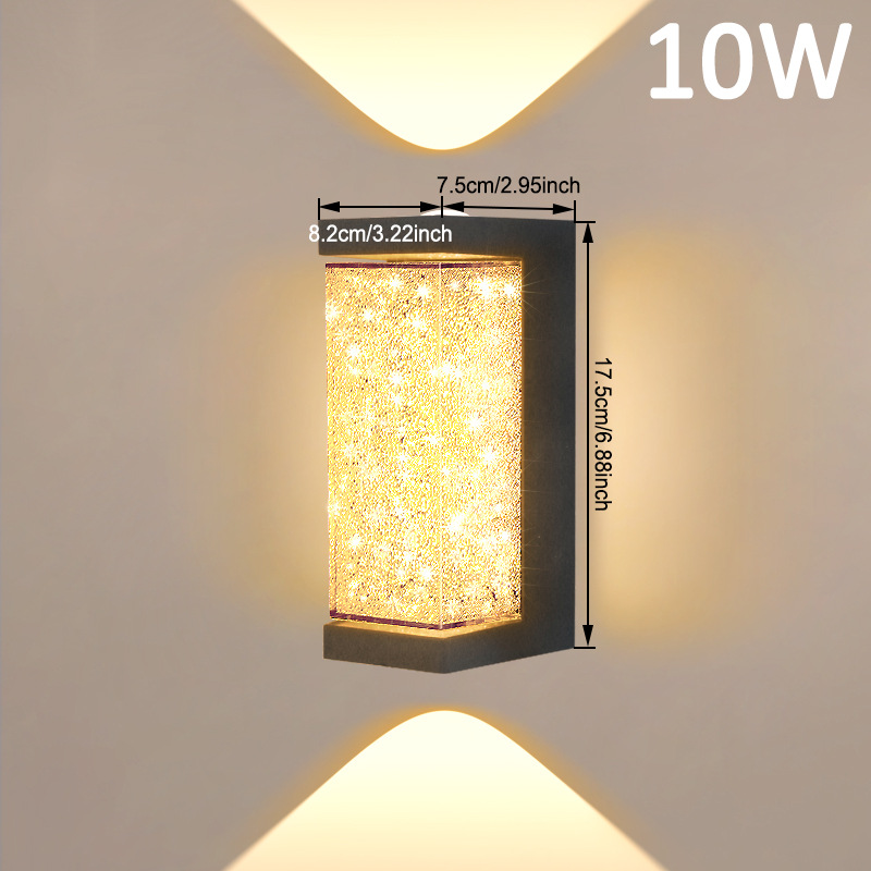 Square LED wall sconce with speckled amber glass cylinder and black frame, warm glow