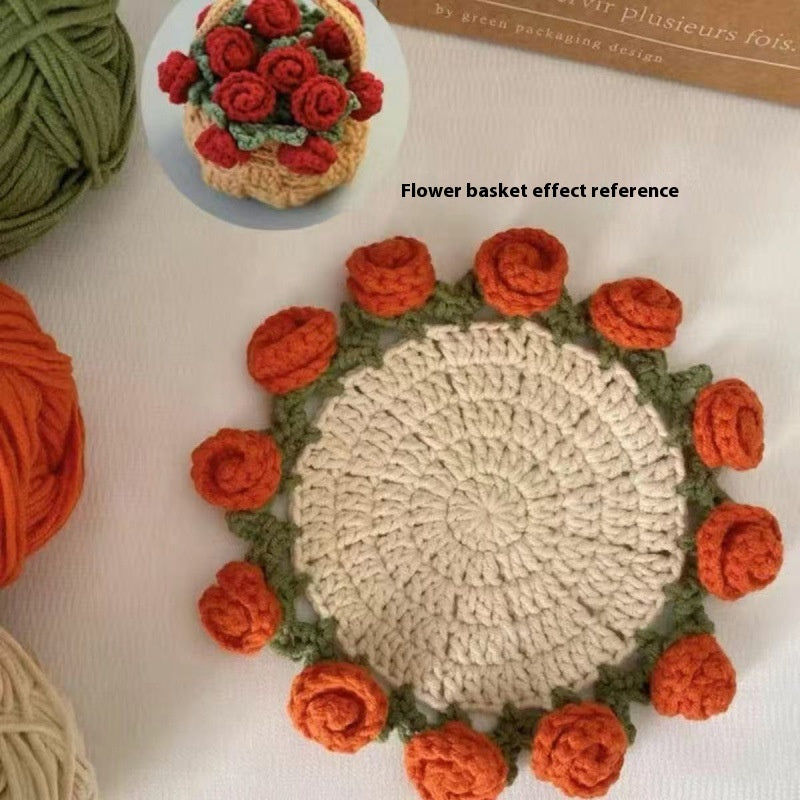 Round crocheted coaster with cream center and orange rose border with green leaf accents