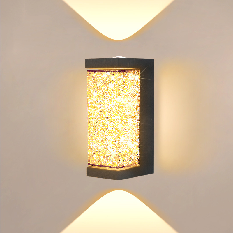 Square LED wall sconce with speckled amber glass cylinder and black frame, warm light