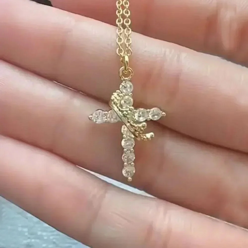 Gold-tone cross necklace close-up with pave crystal stones and linked Y-style chain