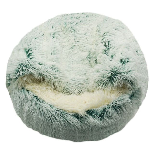 Mint green plush pet bed with raised rim and tunnel entrance, interior cushion visible.