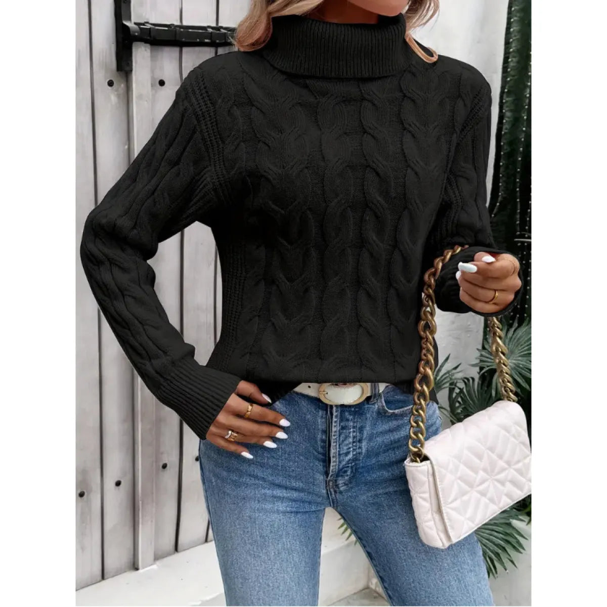 Black cable-knit turtleneck sweater with ribbed collar, cuffs, and chunky pattern