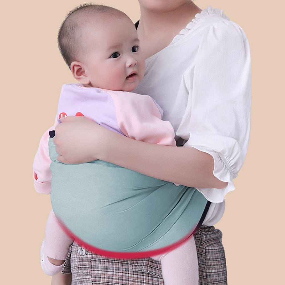 Adjustable baby shoulder carrier sling with green pouch and navy straps, baby supported.