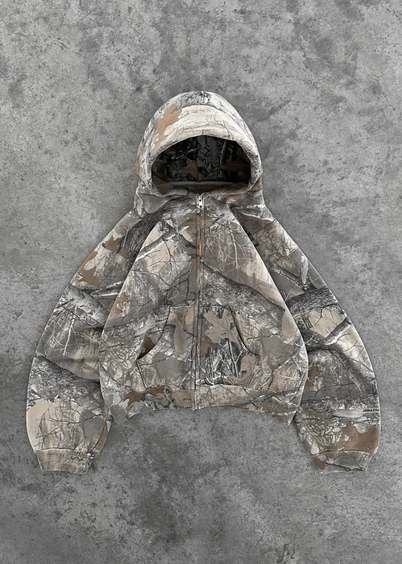 Camouflage zip-up hoodie with attached hood and full-length sleeves, gray tan pattern