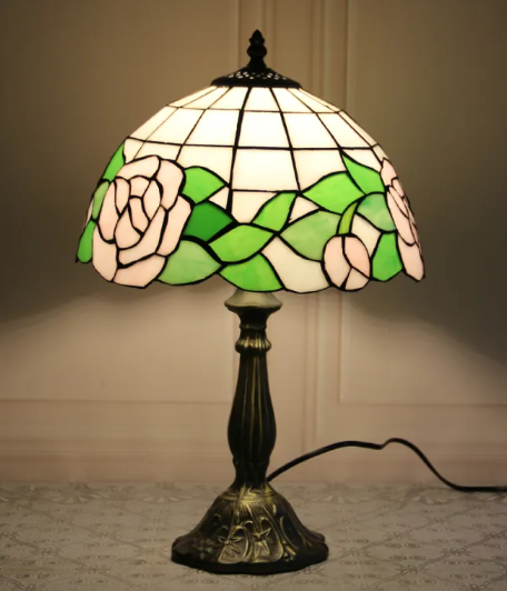 Stained glass bedside table lamp with white and green leaf shade and dark bronze base