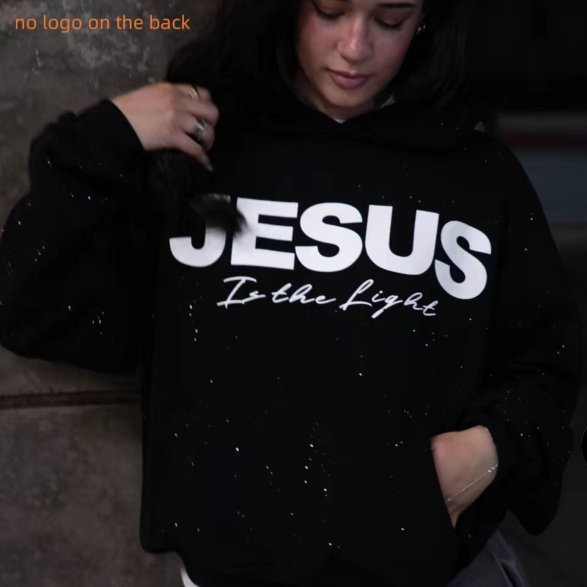 Black pullover hoodie with white “JESUS” graphic on front and drawstring hood