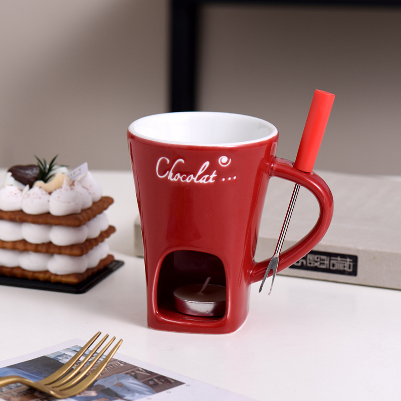Red mini fondue mug with wooden handle, lit warmer, and metal fork