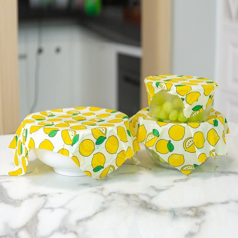 Lemon and fruit-pattern reusable beeswax food wraps, three pack, folded around food