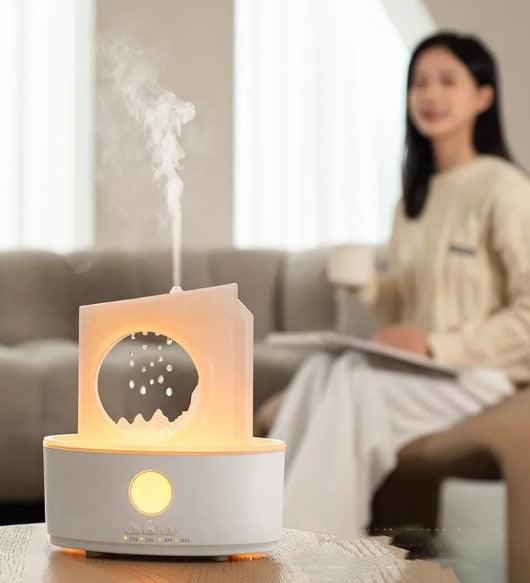 White ultrasonic humidifier emitting mist with warm glowing LED light on top