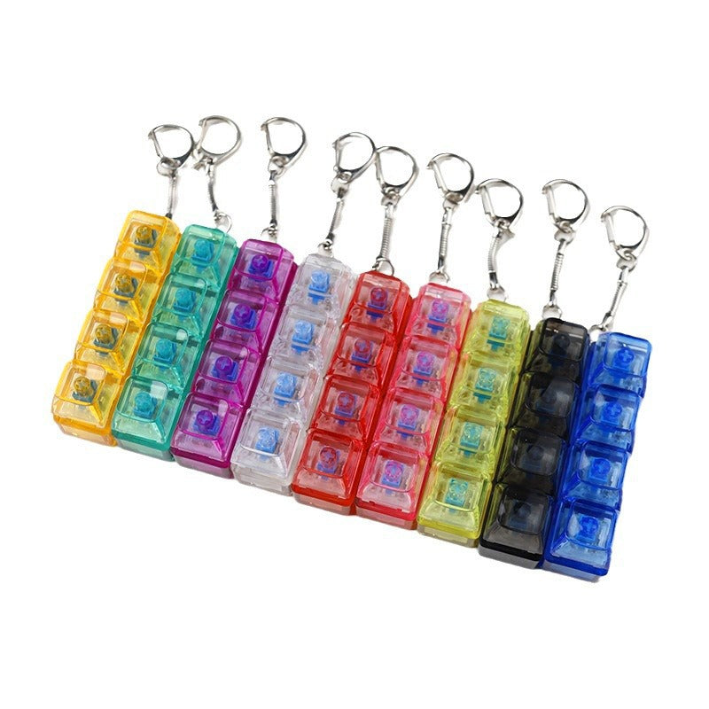 Row of assorted transparent light-up shaft tester fidget toy keychains with metal loops