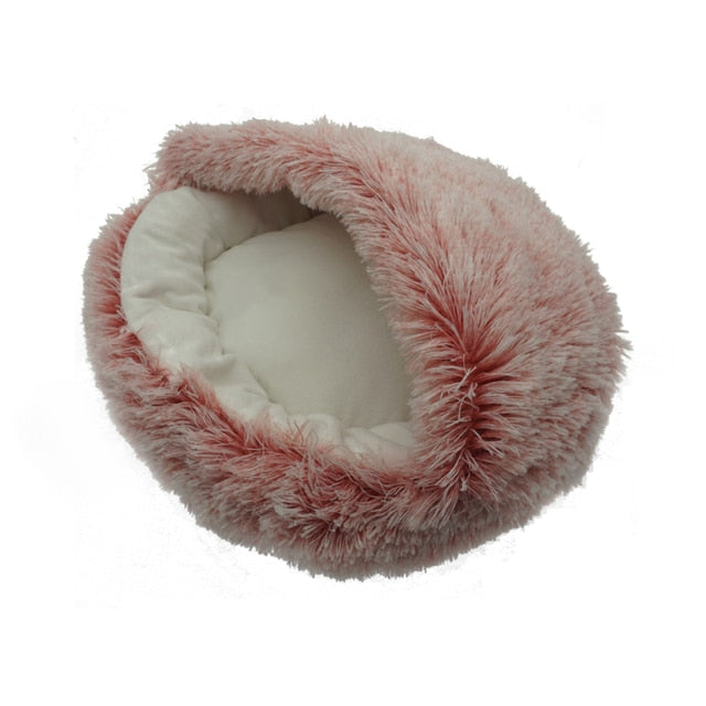 Pink plush pet bed with raised rim and tunnel entrance, empty.