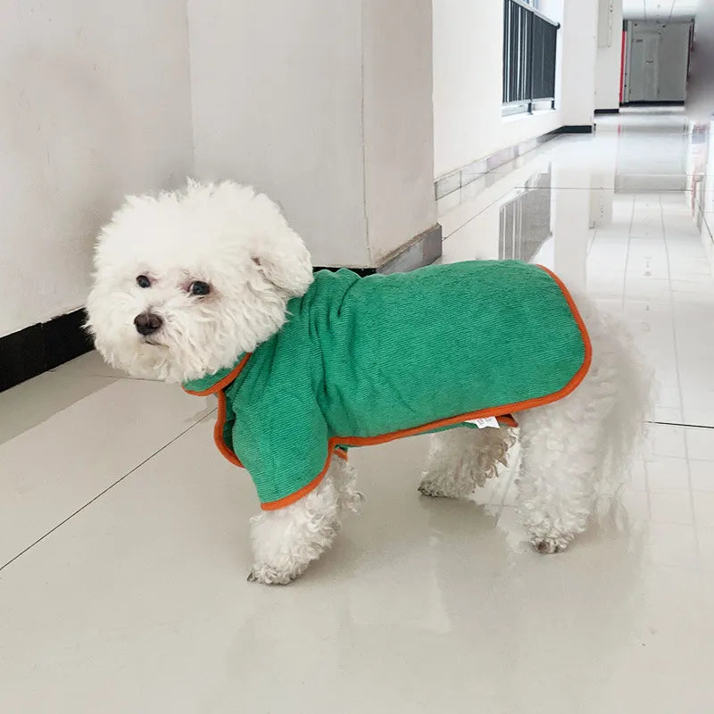 Dog wearing a green microfibre bathrobe towel with orange trim and adjustable neck strap