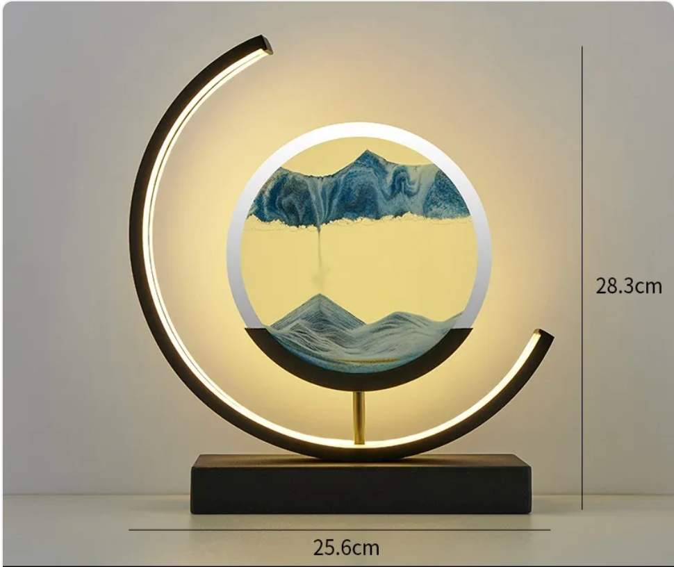 Blue wave glass hourglass table lamp with glowing black LED ring and dark rectangular base.