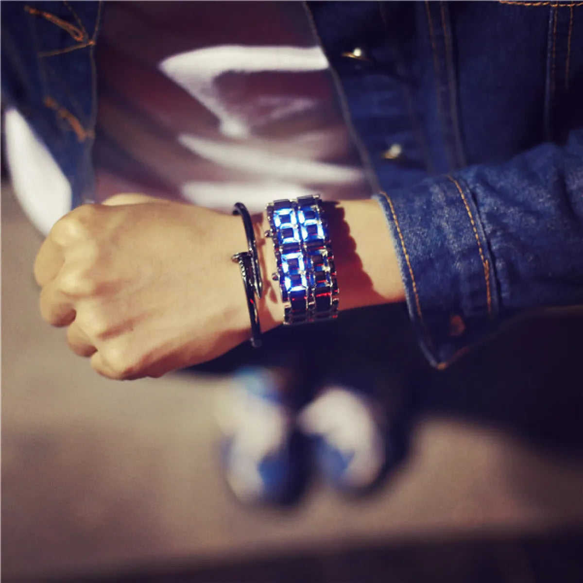 Unisex LED electronic watch with bright blue illuminated display on dark metal bracelet