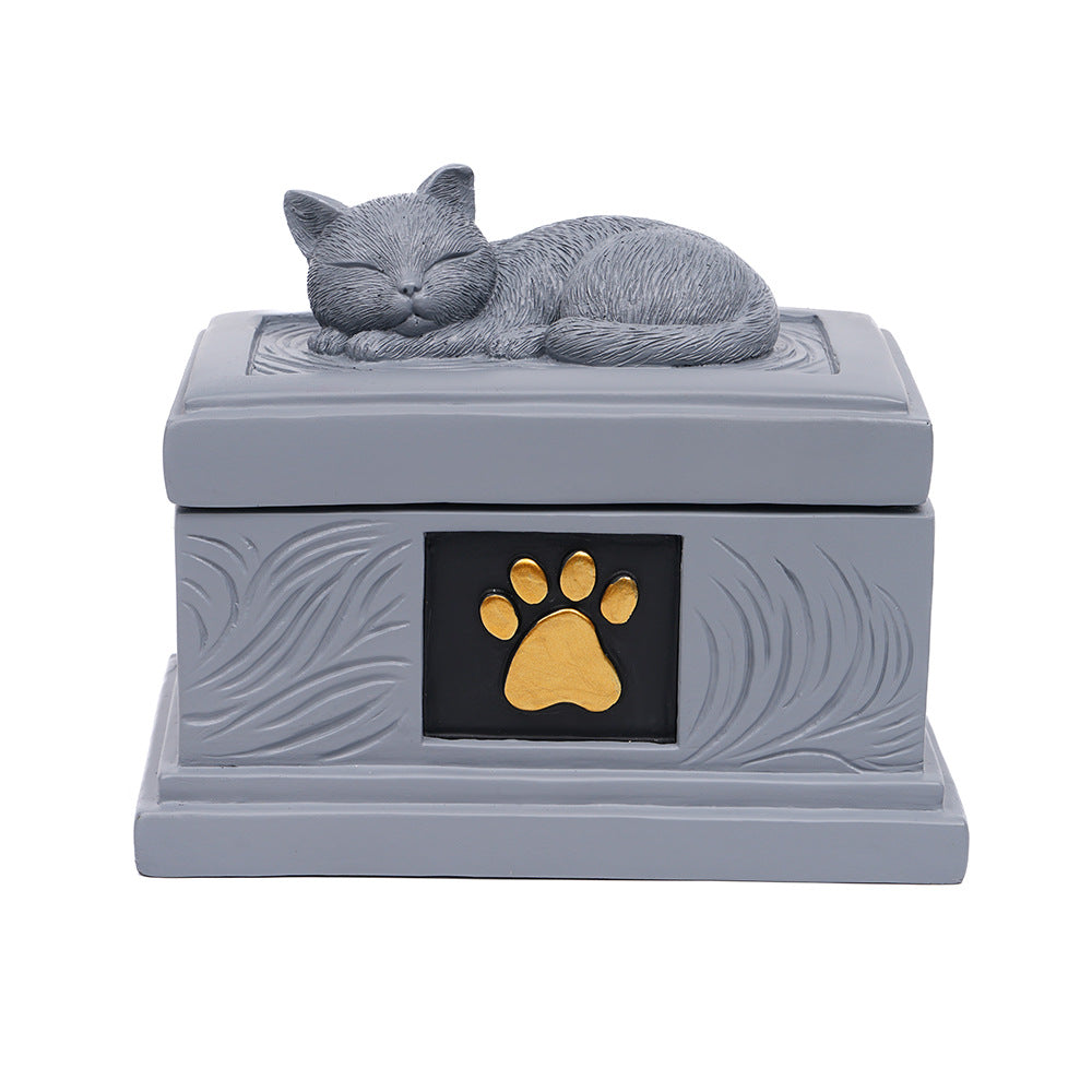 Gray square pet memorial urn with sleeping cat topper and gold paw print emblem
