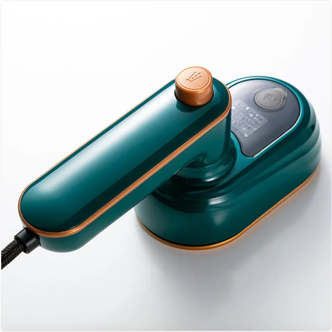 Teal mini steam iron close-up with orange-copper steam cap and side panel