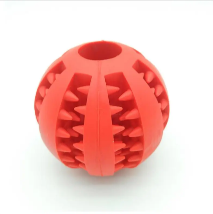 Dog treat dispensing rubber ball in red with raised spike channels and central divider