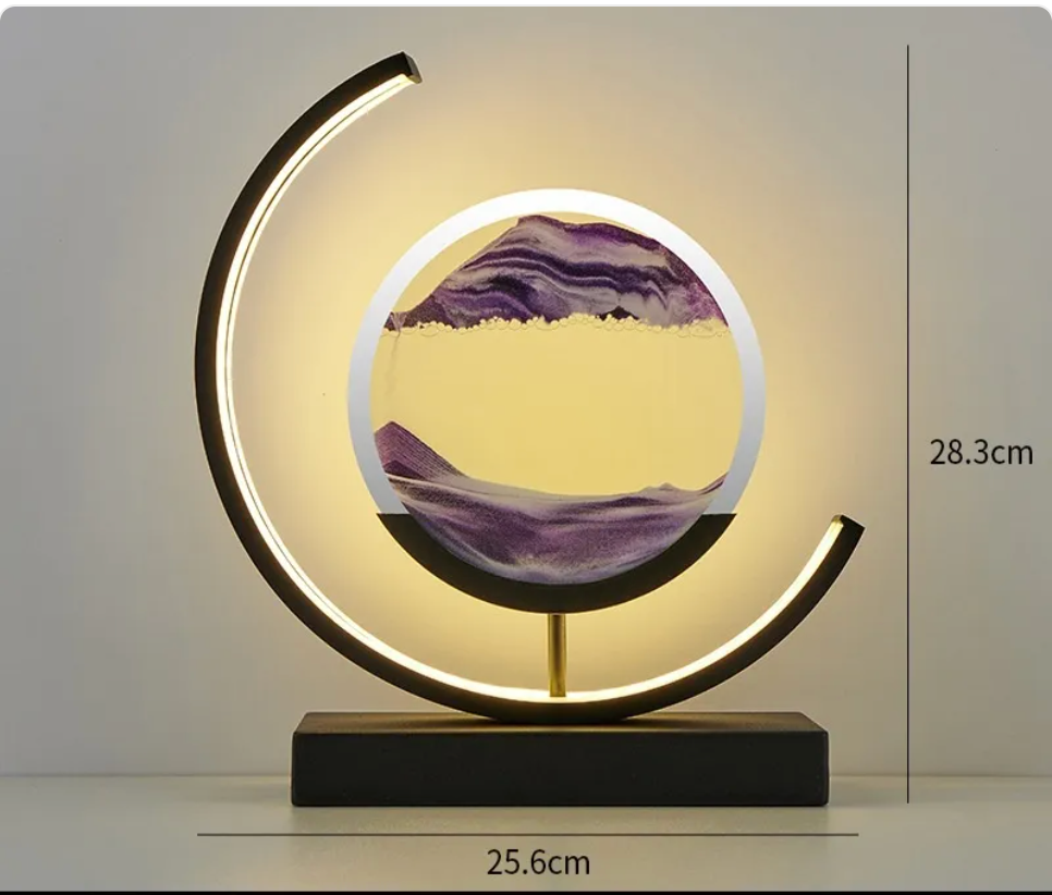 Hourglass table lamp with warm black crescent LED ring, round glass insert, purple wave art, black base.