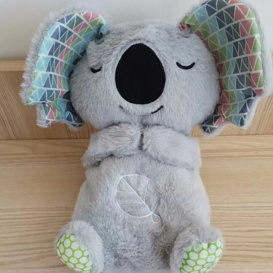 Gray dog plush baby sound machine, smiling face with geometric ear covers.