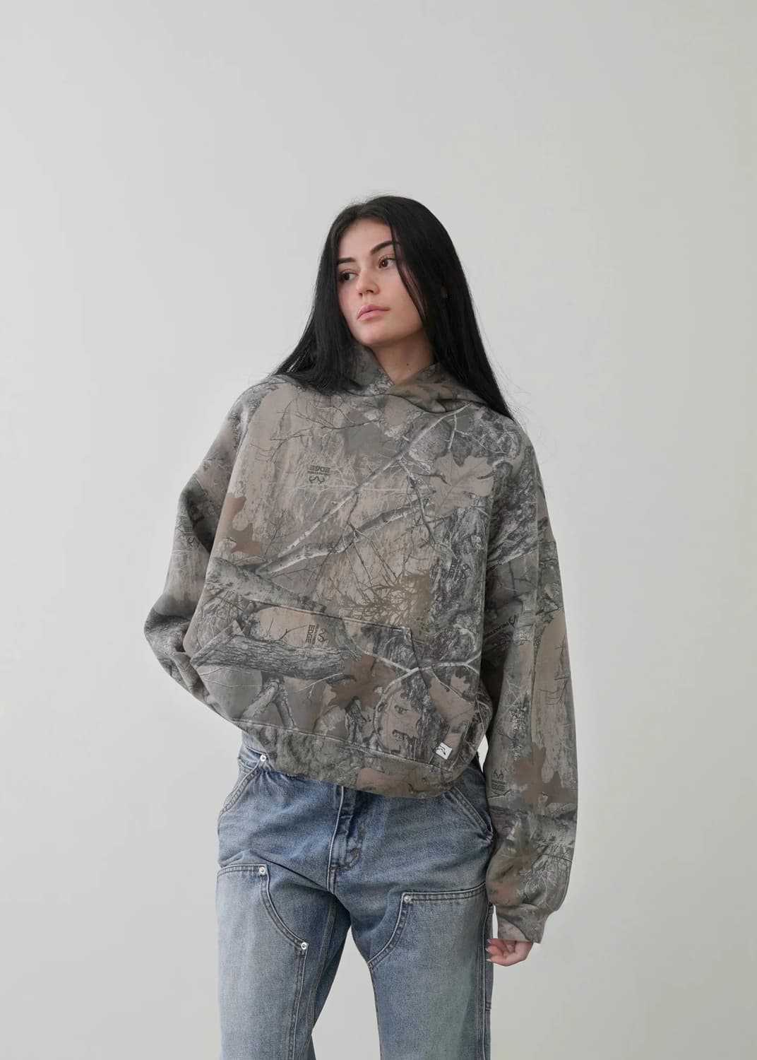 Oversized camo hoodie with long sleeves and hood, side view on model