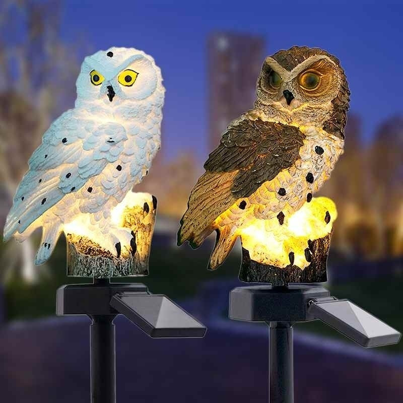 Solar owl garden lamps close view: white and brown owl figures with warm glow