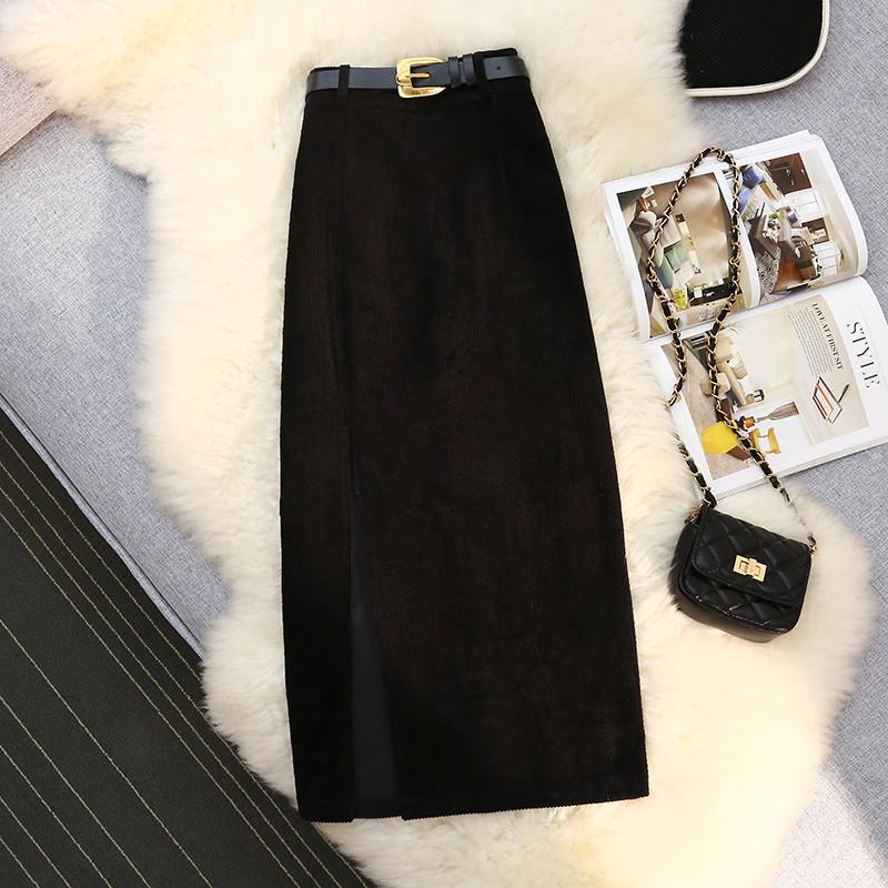 Black high-waist corduroy A-line skirt with front slit, belt strap at waist.