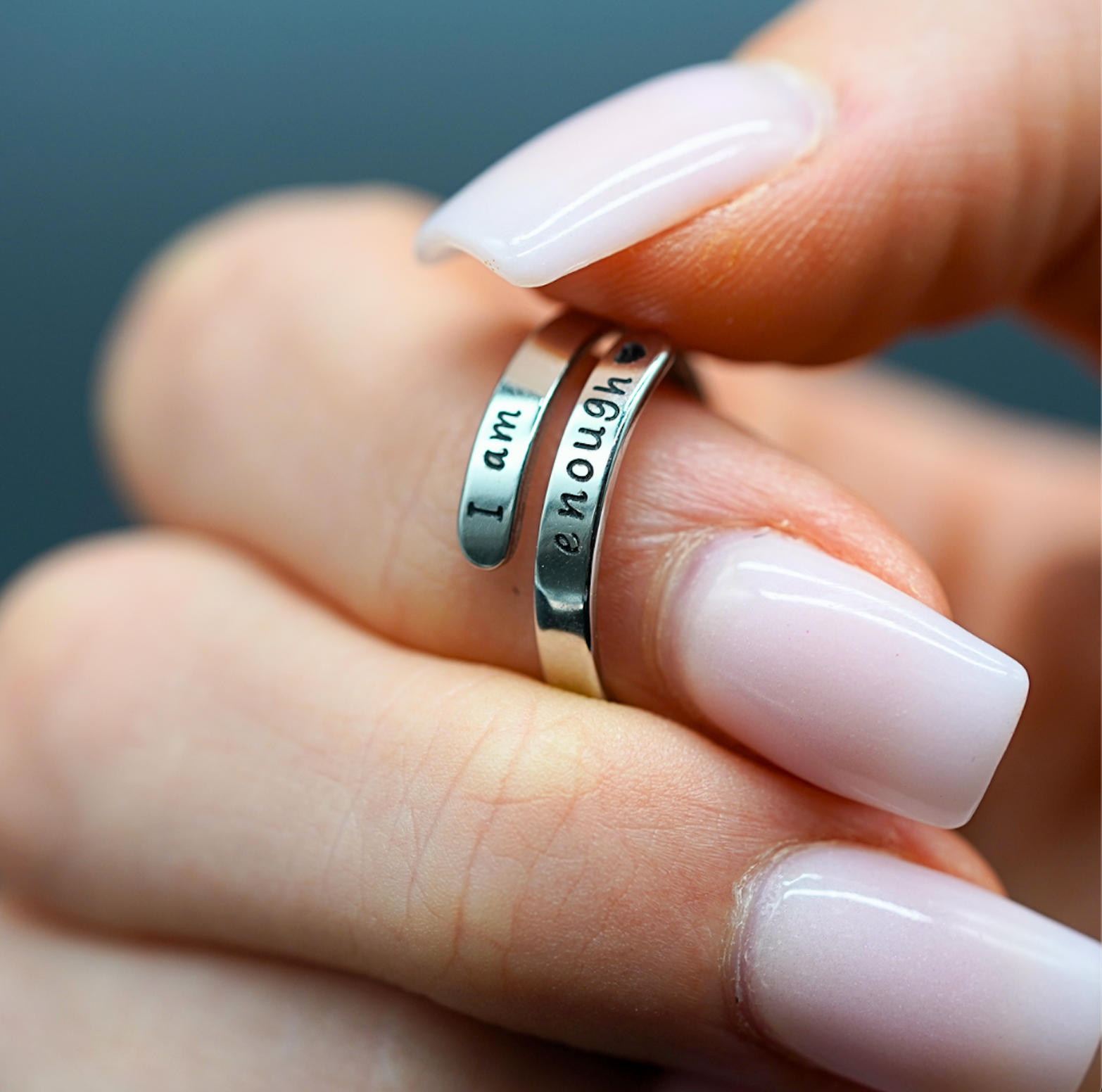 Sterling silver ring with engraved “I am enough” on the band, close-up