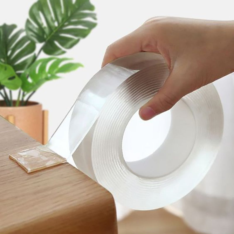 Double-sided transparent tape roll, held in hand