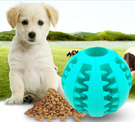 Blue rubber treat-dispensing puzzle dog ball beside a standing puppy