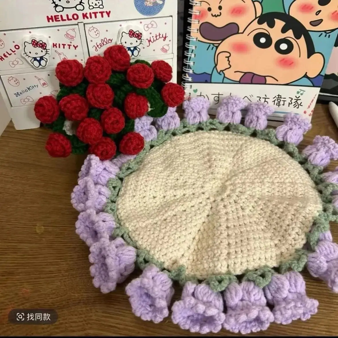 Crocheted coaster with cream center, purple flower rim, and red roses along the top edge