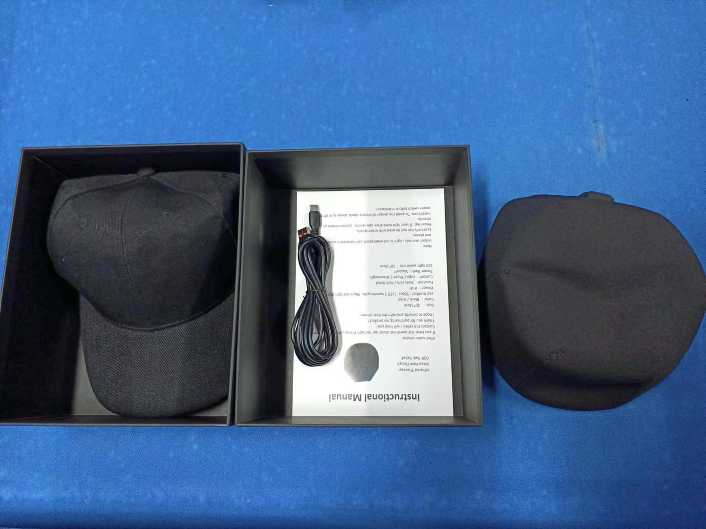 Black LED scalp cap in open box with power cord and accessory pouch.