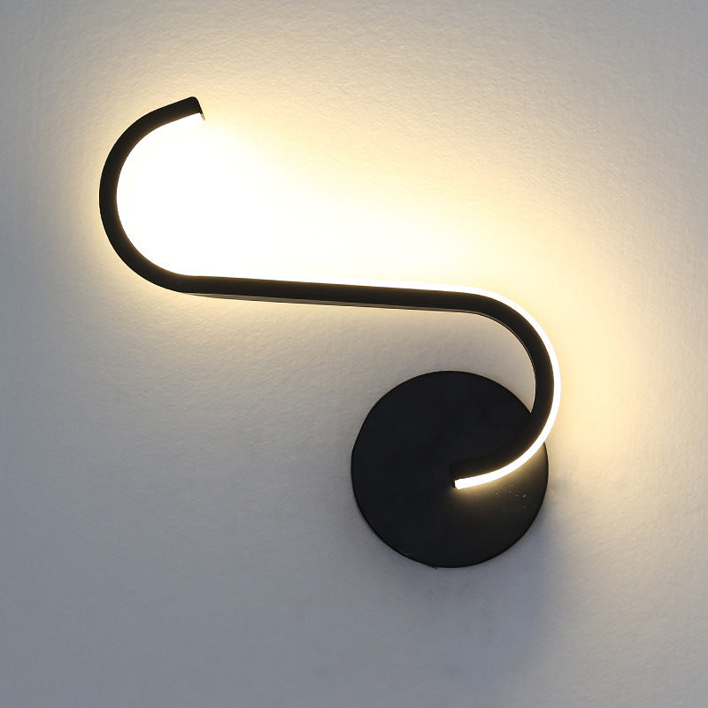 Black LED wall lamp with long curved light tube and round backplate, warm glow.