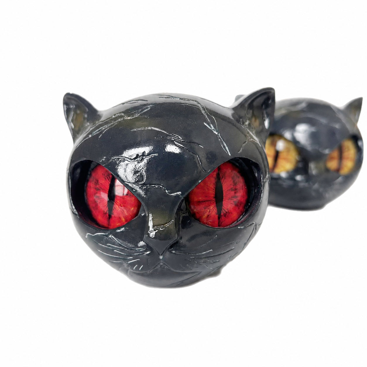 Black resin cat sculpture ornament with red eyes, side view